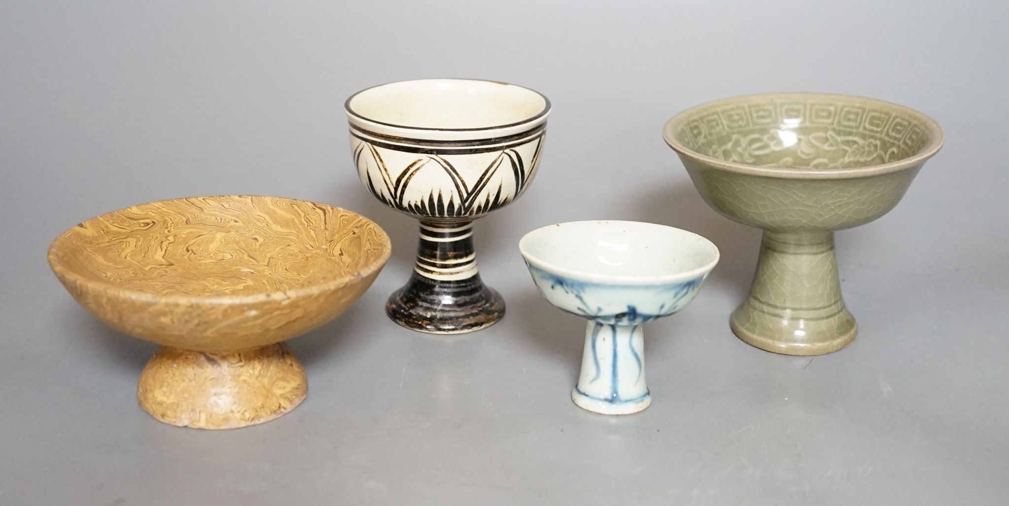 Four various Chinese pottery or porcelain stem cups, tallest 10cm